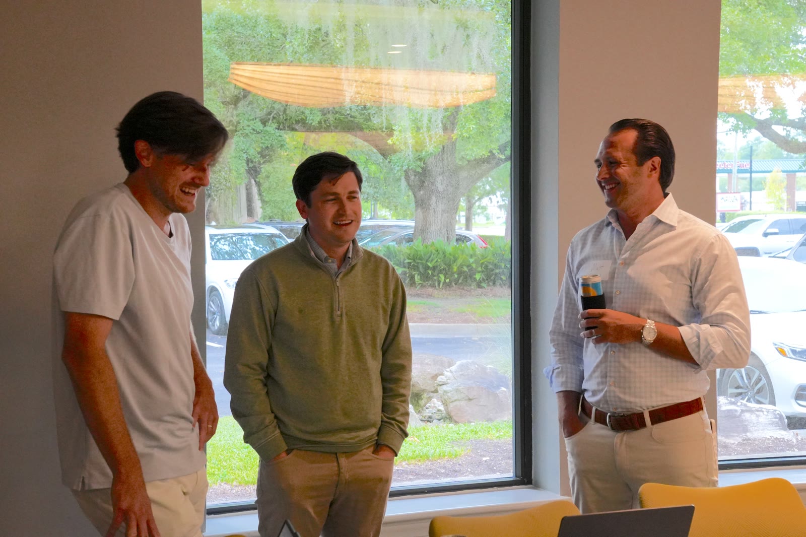Matt Cimino talking with two attendees by a window at the August 27, 2026 AI Roundtable.