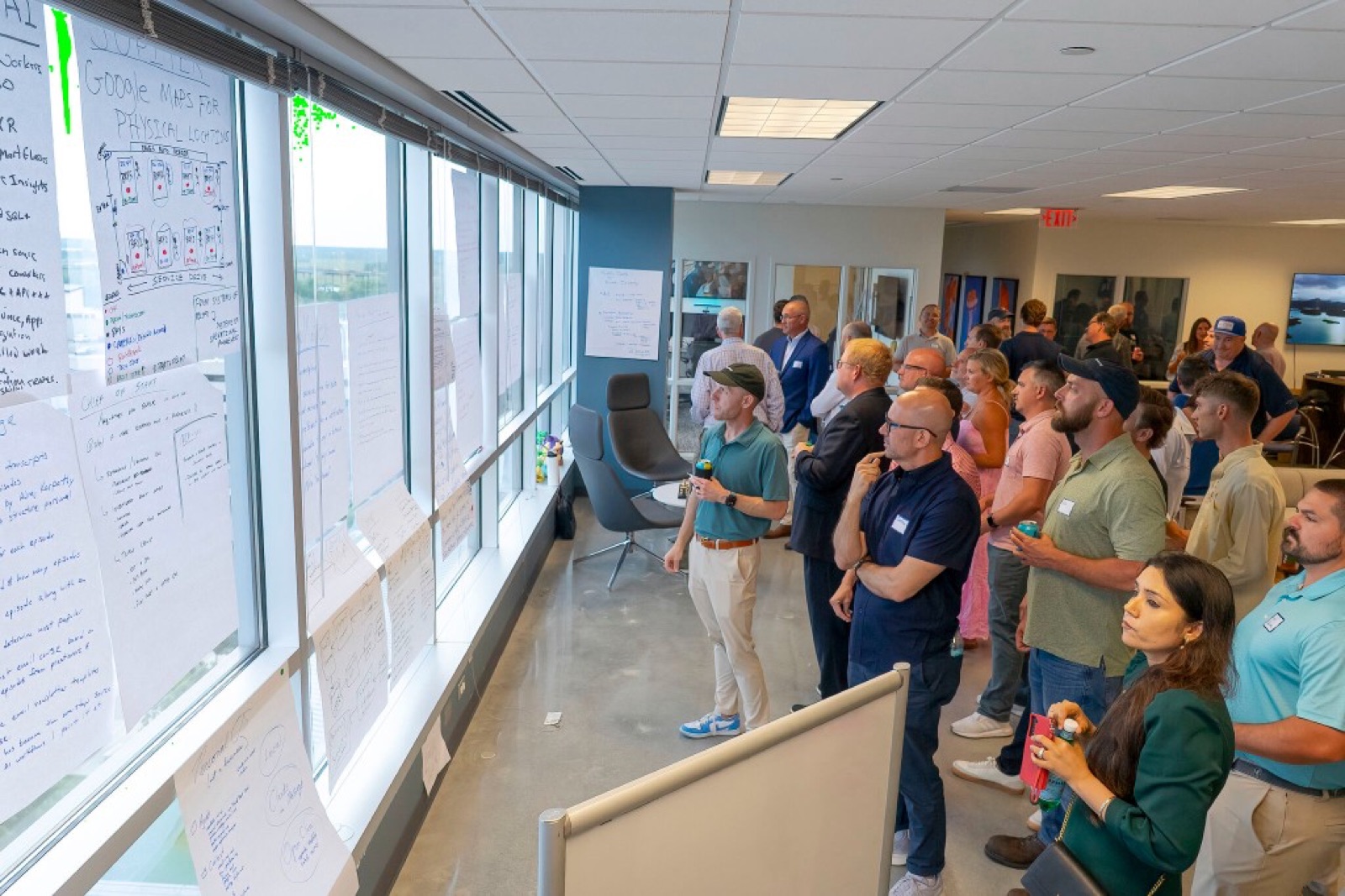 Attendees reviewing startup concepts taped across the windows.